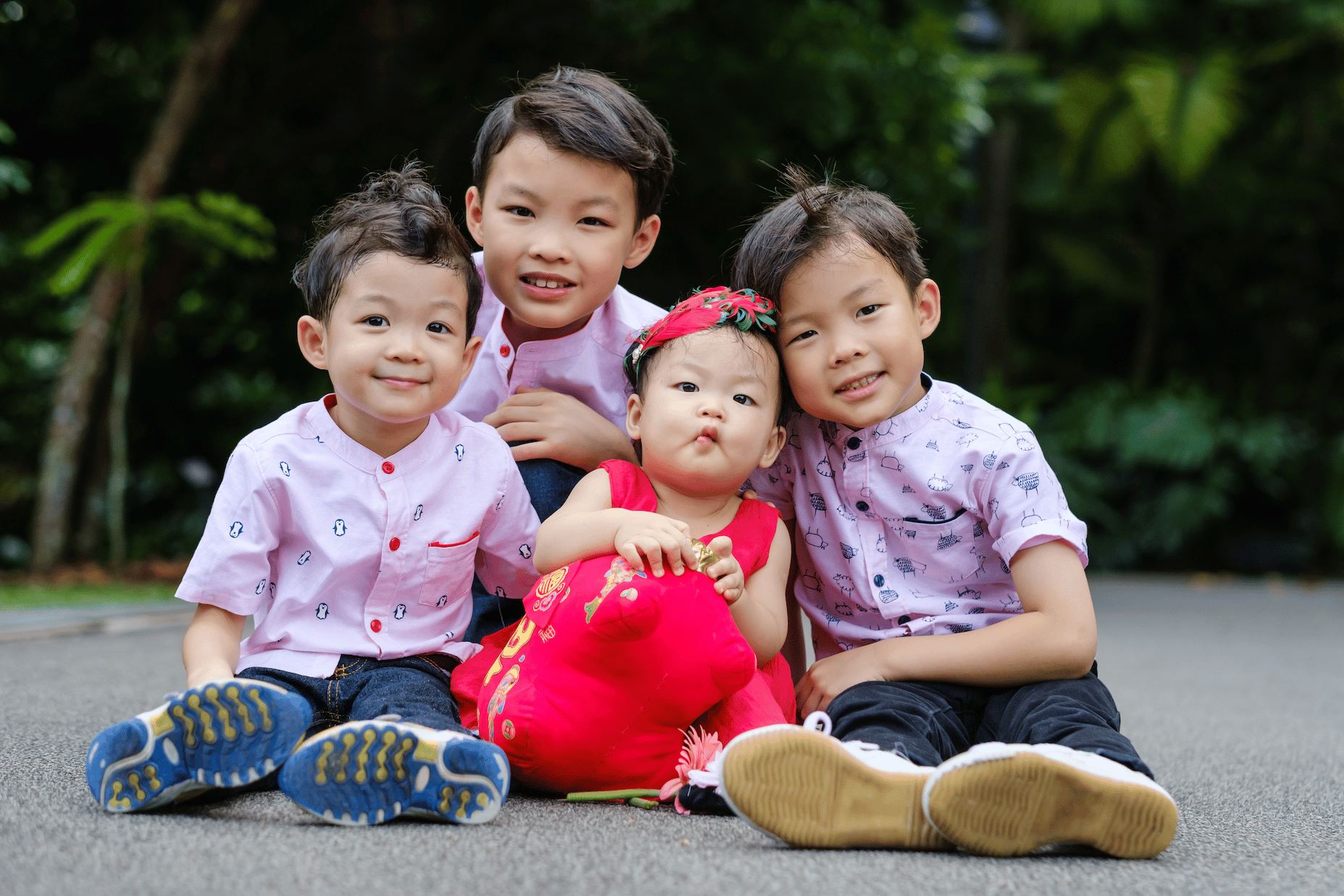 four children sitting on the floor smiling at the camera